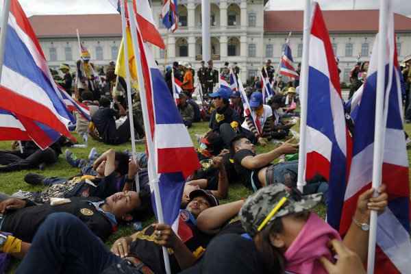 Manifestantes se deitam diante da sede do Comando das Forças Terrestres, em Bangcoc, depois de entregarem uma carta ao secretário-geral do Exército, general Prayuth Chan-ocha