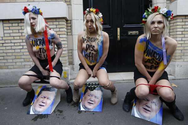 Com a calcinha abaixada, coroa de flores na cabeça, elas urinaram nas fotos do presidente aos gritos de 