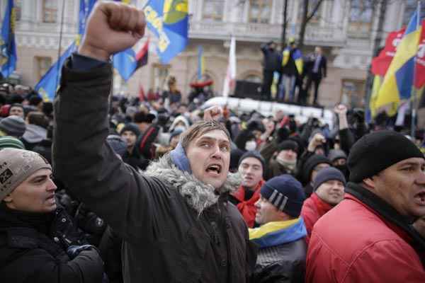 Manifestantes gritam e acenam com bandeiras na frente do parlamento ucraniano, em Kiev