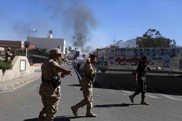 Soldados caminham por estrada que leva ao Ministério da Defesa após ataque, em Sanaa