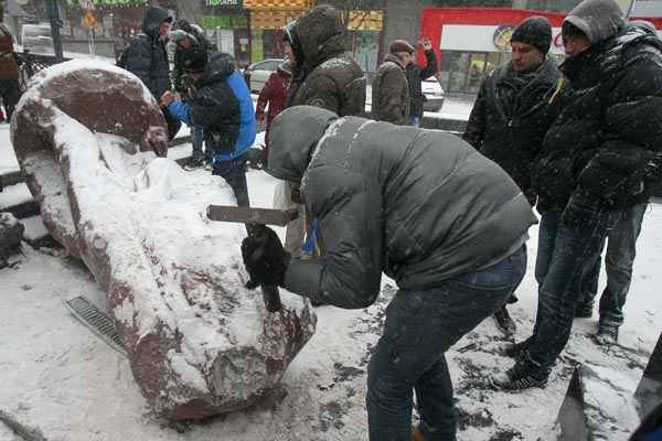 Manifestante martela em estátua de Vladimir Lenin, que foi derrubada em protesto, em Kiev