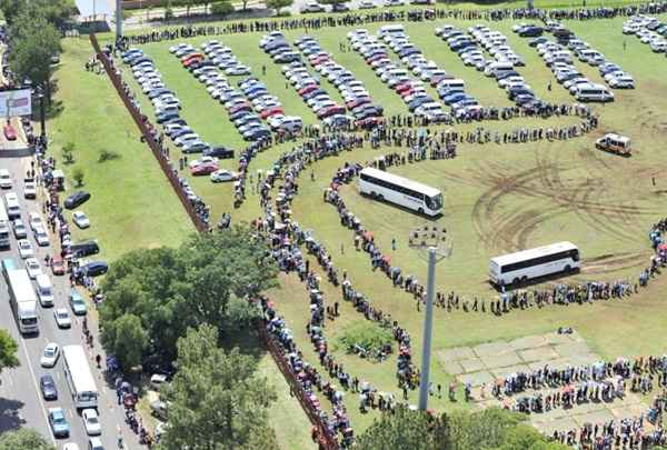 Pessoas na fila para embarcar em ônibus que vai levá-los para os Union Buildings para se despedir de ex-presidente Sul-Africano Nelson Mandela na última quinta-feira (13/12)