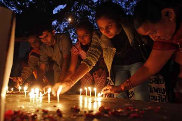 Pessoas acendem velas durante cerimônia de oração para marcar o primeiro aniversário do estupro coletivo, na cidade indiana de Ahmedabad