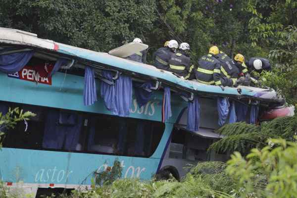 Bombeiros trabalham na remoção das vítimas do acidente com o ônibus da Viação Penha, que ia de Curitiba para o Rio, com 54 pessoas a bordo