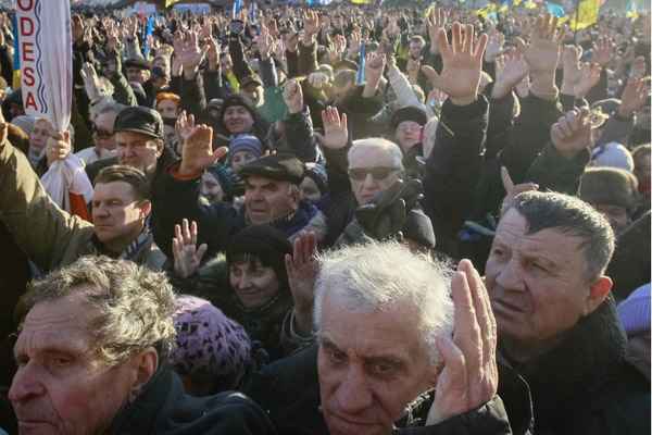 Manifestantes pró-união europeia levantam as mãos durante um comício na Praça da Independência, em Kiev, no dia 22 de dezembro