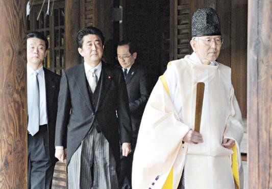 Sacerdote xintoísta (D) recepciona o premiê japonês, Shinzo Abe, no santuário de Yasukuni, em Tóquio