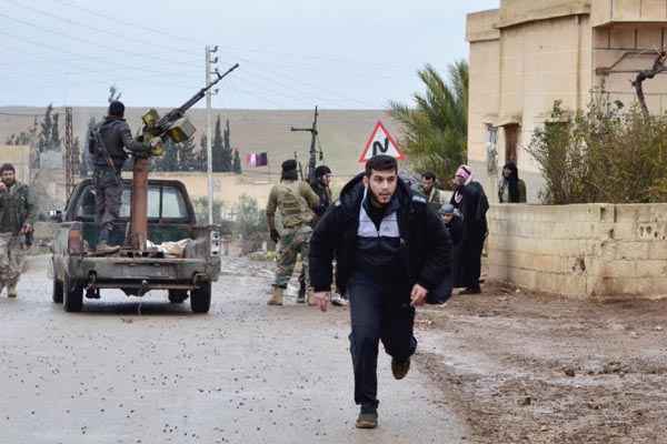 Homem corre durante ação do Exército Sírio Livre, em Hama