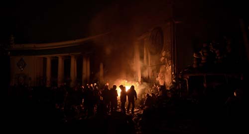 Manifestantes se reúnem em torno de uma fogueira para se aquecer em um bloqueio na estrada em Kiev