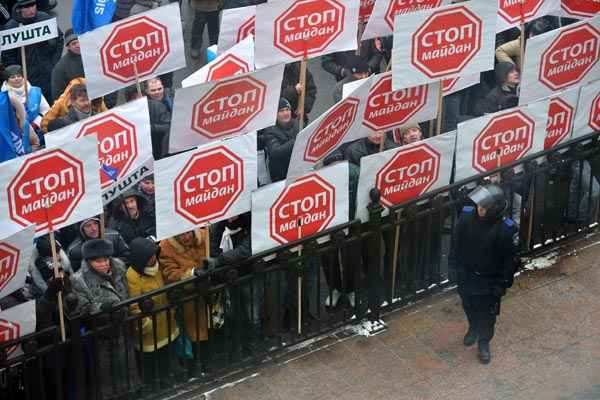 Manifestantes carregam placas em protesto na Praça da Independência, em Kiev