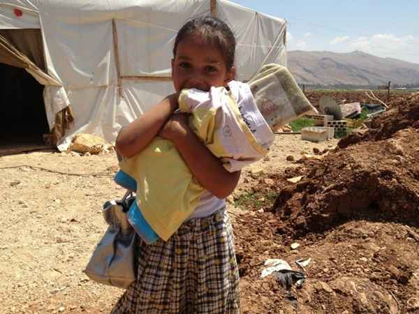 Noura, 7 anos, com uma boneca feita de madeira refugiada na Síria