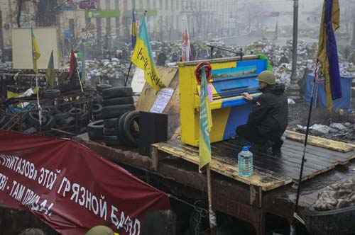 Um manifestante anti-governo toca piano nas barricadas em Kiev