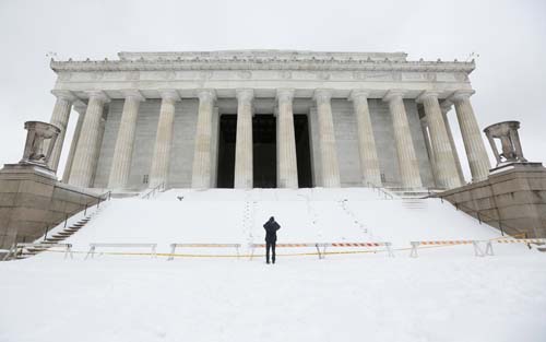 Um homem fotografa a neve que cobriu o Lincoln Memorial , em Washington