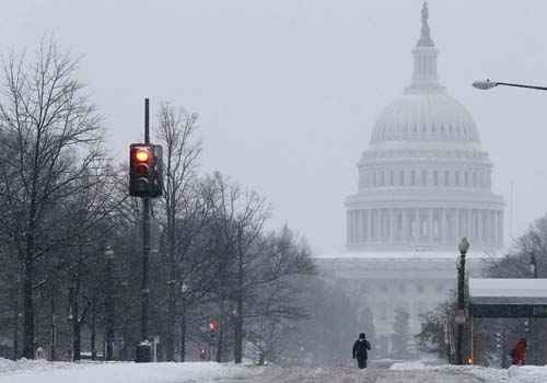 Um pedestre caminha em direção ao edifício do Capitólio dos EUA, nas ruas desertas por conta da grande tempestade de neve que atinge Washington