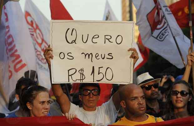 Um dos manifestantes segura um cartaz com a frase 