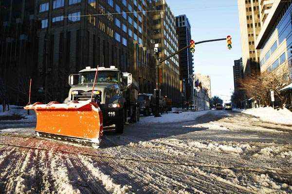 Caminhão limpa rua de gelo e neve após noite de tempestade, em Nova Jersey