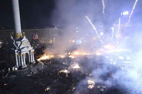 Manifestantes anti-governo usam fogos de artifício durante confrontos com membros do Ministério do Interior e policiais na Praça da Independência no centro de Kiev