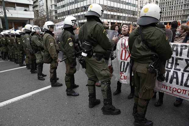 Manifestantes proclamam palavras de ordem em frente à barreira policial