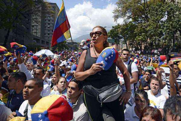 Vestidos de branco, os jovens carregavam cartazes com dizeres contra o governo de Nicolás Maduro e gritavam palavras de ordem