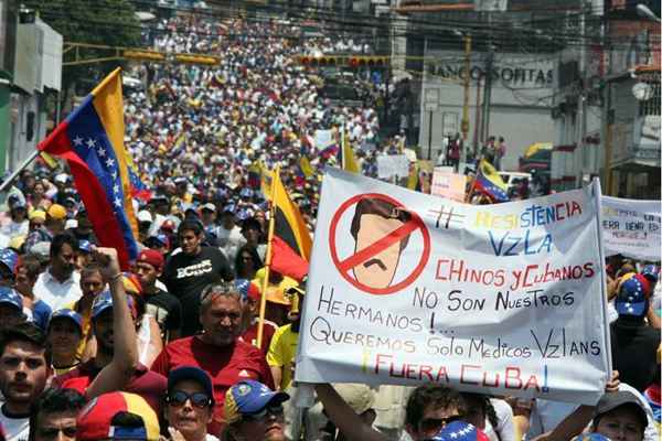 Ativistas da oposição marcham durante um protesto contra o governo do presidente da Venezuela, Nicolas Maduro, em San Cristobal em 5 de março de 2014. Sobe para 19 o número de mortos nas manifestações que há um mês acontecem na Venezuela