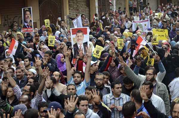 Partidários do presidente islamita Mohamed Mursi, que foi derrubado pelo exército após manifestações contra o seu governo em julho passado, gritam slogans durante um protesto na área Omranya, ao sul do Cairo.