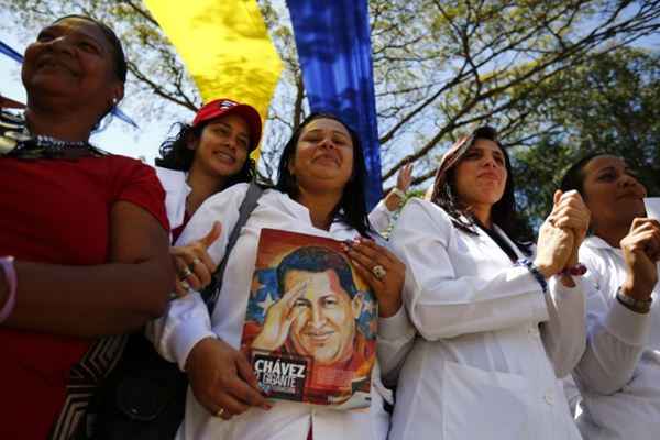 Médicos comunitários da Venezuela seguram imagem do falecido presidente venezuelano, Hugo Chávez