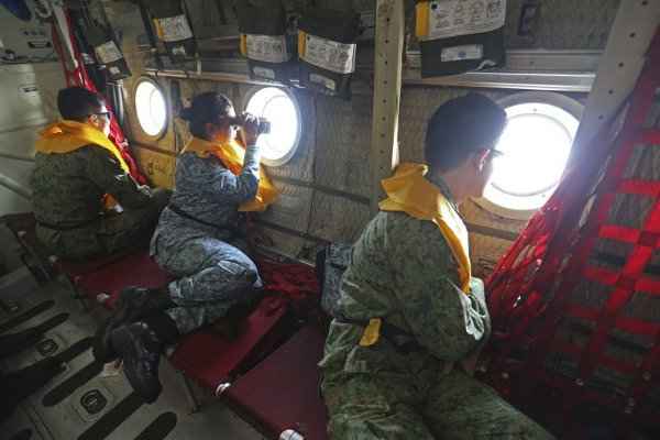 Militares de Cingapura observam o Mar do Sul da China, a bordo de um cargueiro C-130, à procura dos destroços: buscas na região errada