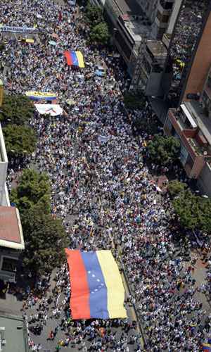 Levando grandes cartazes e faixas com mensagens de 'Cuba fora das Forças Armadas' e 'Fora espiões cubanos', a multidão caminhou até a embaixada cubana no leste de Caracas