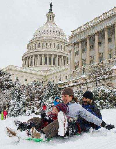 Família desliza na colina no Capitólio dos EUA, em Washington, após mais uma tempestade de neve