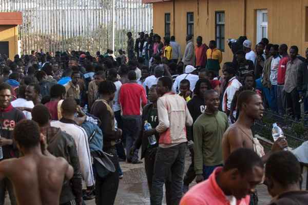 Imigrantes se reúnem no pátio de um centro de detenção temporária de imigrantes depois de cruzar a fronteira do Marrocos ao enclave norte-Africano da Espanha de Melilla