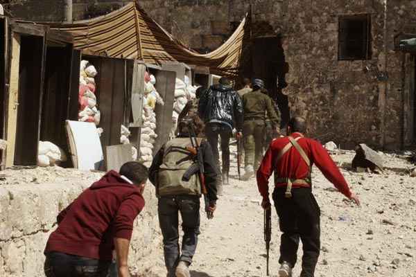 Rebeldes carregam armas para a sede da polícia e o Palácio da Justiça na antiga cidade de Aleppo