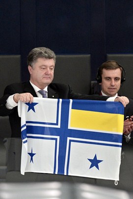 Petro Poroshenko segura bandeira de um comandante da Marinha ucraniana durante um debate em sessão plenária do Parlamento Europeu