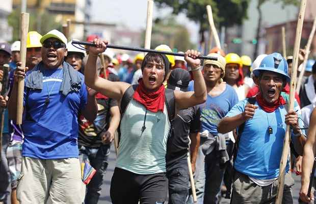 Garimpeiros segurando paus e gritam em marcham contra o governo do Peru durante um protesto no centro de Lima