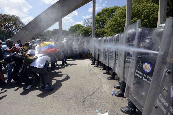 Agentes da Polícia Nacional Bolivariana lançam gás lacrimogêneo contra estudantes, em recente protesto na capital, Caracas: 35 mortos em 45 dias