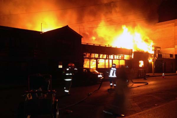 Bombeiros tentam extinguir um incêndio em um restaurante na praia do mar após o terremoto