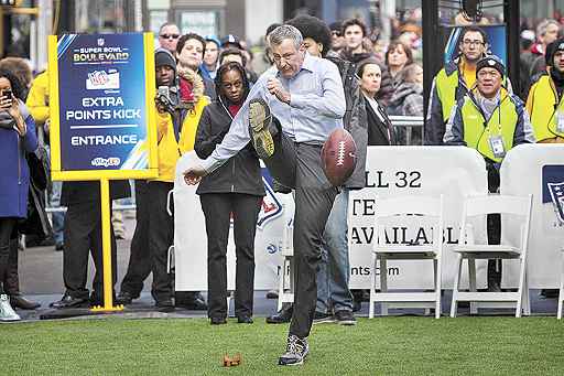 O prefeito tenta acertar chute em ato de promoção do Superbowl, a grande final do futebol americano: três meses de boas intenções com resultados insatisfatórios