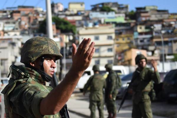 Soldados brasileiros patrulham a rua durante as operações de segurança no Parque União - parte do complexo Maré