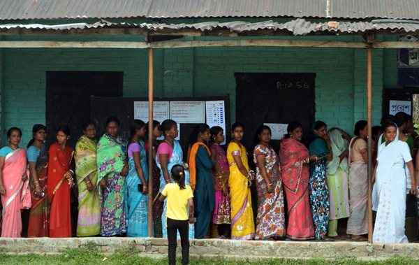 Eleitores indianos esperam na fila do lado de fora de uma votação, em Dibrugarh