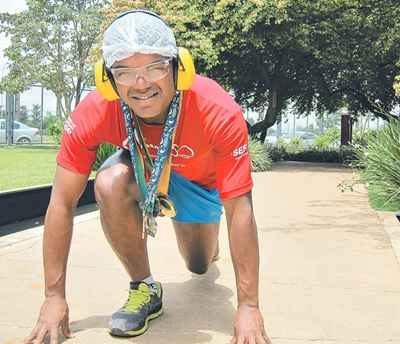 Com a touca e o protetor que usa na fábrica, Elias brinca e mostra as medalhas: 20 provas só no ano passado