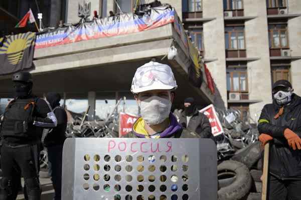 Manifestantes pró-russos se reúnem em barricada diante de prédio do governo regional, em Donetsk