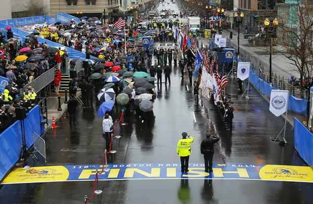 Sobreviventes e socorristas participar de uma cerimônia de hasteamento da bandeira na linha de chegada em Boston