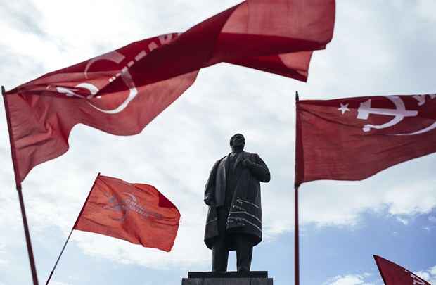 Defensores do Partido Comunista da Ucrânia estenderam bandeiras vermelhas em frente à estátua do fundador da União Soviética, Vladimir Lenin