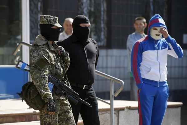 Homens se posicionam em frente do prédio da administração da cidade de Kostyantynivka, na Ucrânia