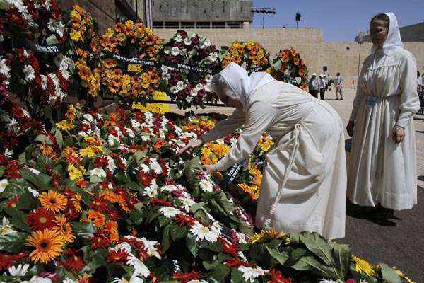 Freira coloca coroa de flores após cerimônia que marcou o Dia do Holocausto, em Yad Vashem, Jerusalém