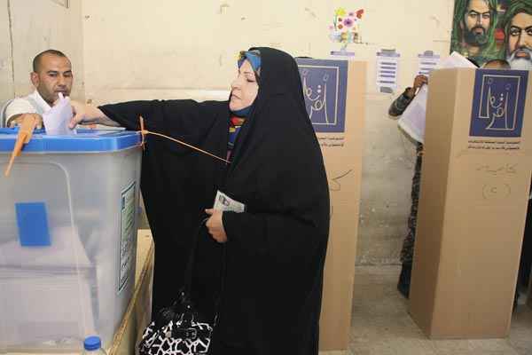 Mulher lança voto em urna durante pleito antecipado para a eleição parlamentar, em Bagdá