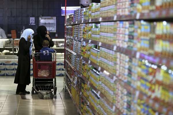 Refugiados sírios fazem compras em um mercado depois de receber ajuda humanitária de vales de compras no novo campo de refugiados perto de Azraq