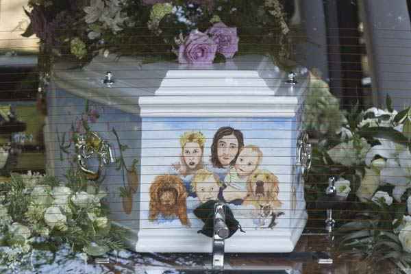 Um carro fúnebre carregando o caixão de Peaches Geldof, pintado com uma foto de sua família, chega no funeral