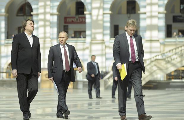 O presidente russo, Vladimir Putin (C), o porta-voz Dmitry Peskov (D) e o diretor geral do canal One Rússia Konstantin Ernst, em Moscovo