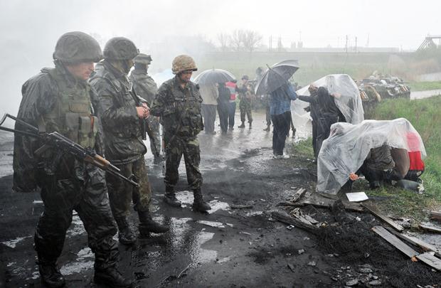 Manifestantes pró-russia se abrigam da chuva em bloqueio militar