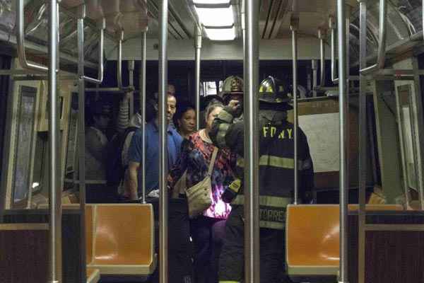 Bombeiros dão instrução aos passageiros sobre a forma de sair dos vagão do metrô depois do descarrilamento