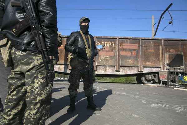 Homens armados pró-Rússia fazem guarda em posto de controle de ferrovia perto da cidade de Slaviansk, no Leste da Ucrânia